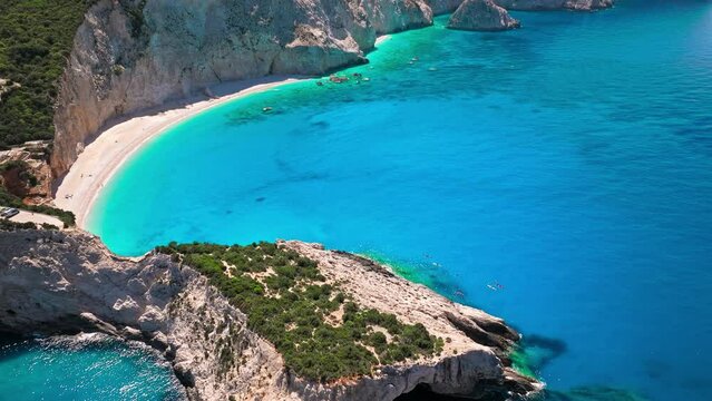 Porto Katsiki beach with turquoise water bordered by concave pale cliffs. Aerial view of crystal clear blue waters with picturesque views on the Ionian island of Lefkada, Greece.