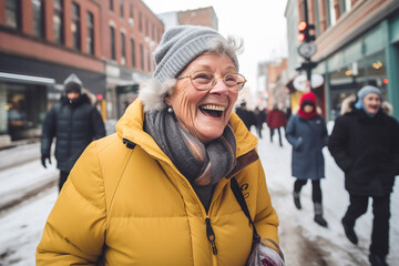 Delighted grandmother laughs against people walking on city street. Senior woman in glasses shows...