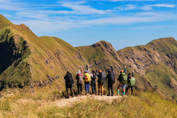 Group of hiking or hiker people stand in mountains and looking the target to go mountain peak at...