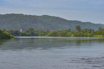 A big river in summer among the hills.
