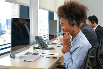 a young african american female using headsets to communicate and service customer in call...