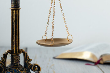 Close-up of ancient scales of justice and open holy bible book with white background. Close-up....