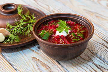 Ukrainian borscht in clay bowl, in rustic style. (Beet Soup). Borsch served in clay bowl with sour...