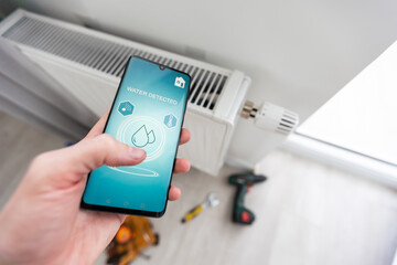 Close up focus on cellphone with smart home software application on screen, wireless light music temperature regulation with digital gadget, air conditioner climate control, iot, virtual assistant