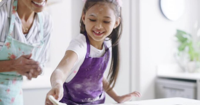 Mother, girl and happy with baking in kitchen with fun for learning, child development and bonding with play at home. Family, woman and daughter with apron for cooking, support and dessert with love