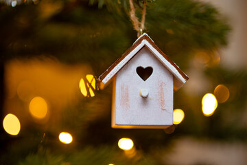 Wooden Christmas ornament on a tree with light in the bokeh background