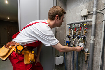 maintenance - technician checking pressure meters for house heating system.
