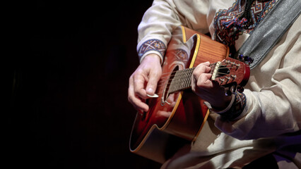  guitarist playing an acoustic guitar.