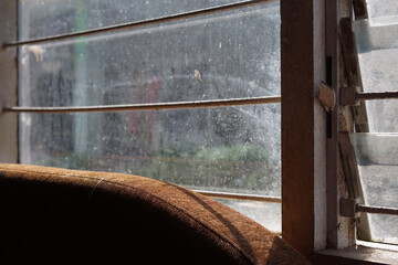 The living room of the house with wooden and paper partitions that block sunlight from the windows, a sofa with black metal accents, natural colors.