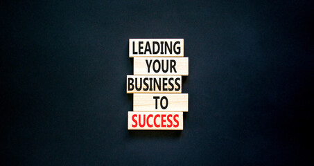 Leading your business to success symbol. Concept words Leading your business to success on wooden blocks. Beautiful black table black background. Leading your business to success concept. Copy space.