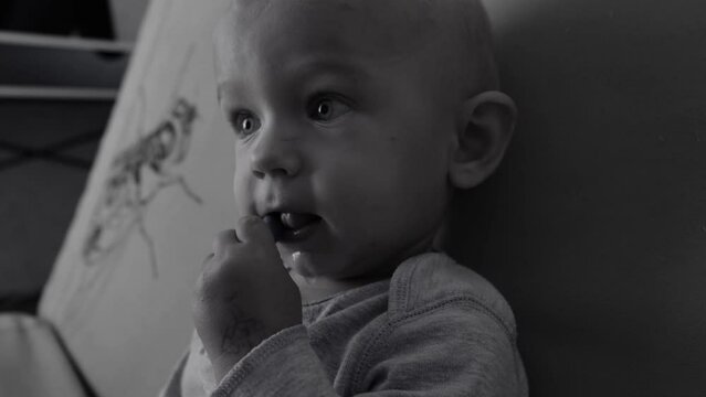 A poignant black and white video of a baby in an orphanage, depicting the child's innocence and vulnerability against a monochrome backdrop. baby, living in an orphanage.