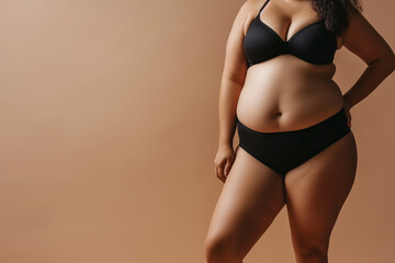 Fototapeta premium Confident Plus-Size Woman in Elegant Black Swimwear on Neutral Backdrop