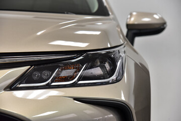 Headlight of a beige car. Close-up.