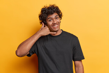 Indoor shot of young delighted smiling broadly Hindu male student standing in centre isolated on...