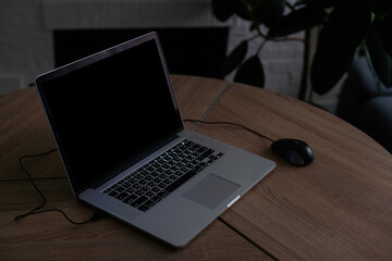 laptop with blank screen on wooden table