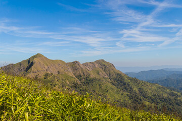 Green yellow mountains and beautiful sky clouds under the blue sky.