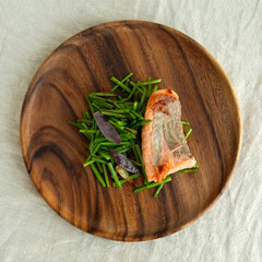 wooden plate with grilled salmon with asparagus on the table