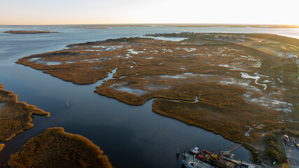 Aerial view of a wetland ecosystem with intricate water patterns and marsh vegetation at dusk.