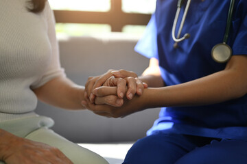 Cropped shot of caring nurse holding senior woman hands for hope and supporting. Elderly healthcare...
