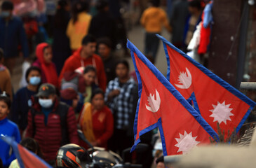Nepal national flags with the crowded burred people and street view background 