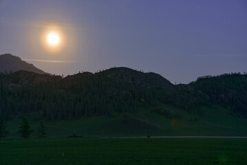 Mountain landscape in the mountains with the moon. Twilight.