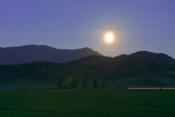 Mountain landscape in the mountains with the moon. Twilight.