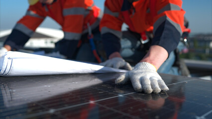 Engineer and technician working on the solar panel on the warehouse roof to inspect the solar...