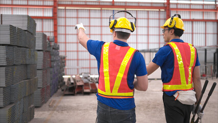 Warehouse workers in hard hats and helmets, Inspect and count steel in the warehouse.