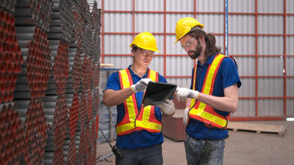 Warehouse workers in hard hats and helmets, Inspect and count steel in the warehouse.