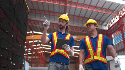 Warehouse workers in hard hats and helmets, Inspect and count steel in the warehouse.