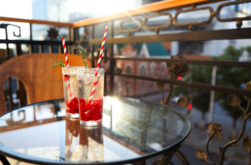 Summer refreshing lemonade with rasberry on a balcony of terrace