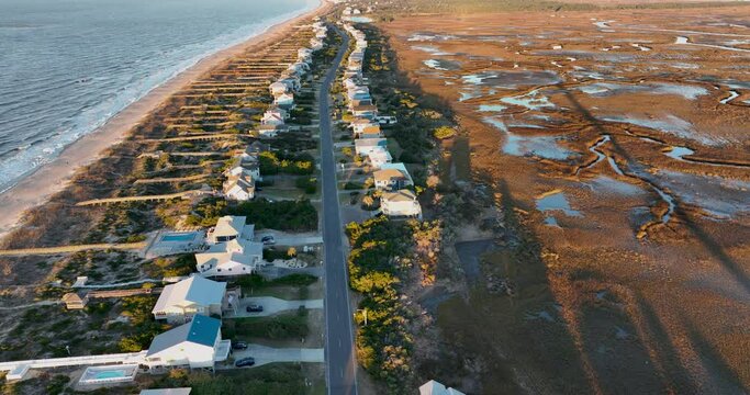 Sunrise at Oak Island, North Carolina, casts a warm glow over beachfront homes and marshlands.