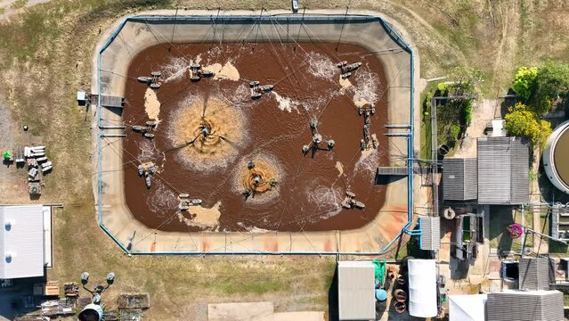 An industrial wastewater treatment pond is a vital facility in manufacturing, purifying wastewater through natural processes. It aids in reducing environmental impact. Bird's eye view by drone.
