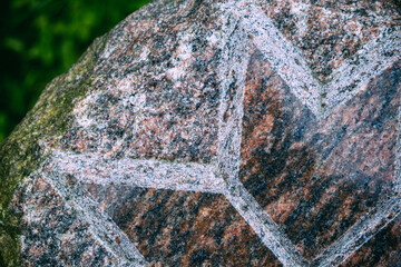 polished granite surface with engraved symbol. Macro close up.