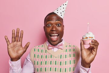 Birthday celebration concept. Indoor waist up of young cheerful smiling broadly African american...