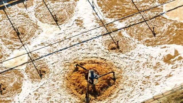 An industrial wastewater treatment pond is a containment area designed to treat and purify wastewater from factories and plants. It utilizes natural processes to remove contaminants. Drone view.
