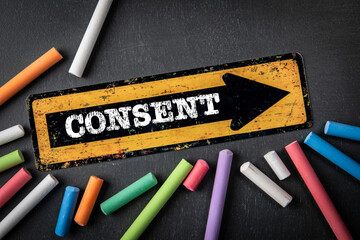 Consent. Direction arrow with text on a dark chalkboard background