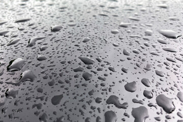 Large drops of water on a black glossy surface