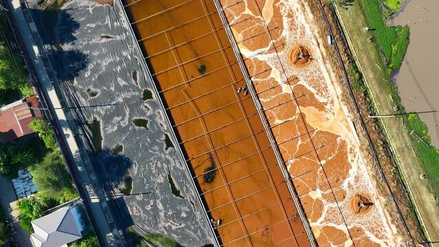 An industrial wastewater treatment pond is a vital facility for purifying contaminated water from manufacturing processes. It employs various methods to remove pollutants. Aerial view drone.

