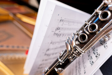 Clarinet in front of sheet music on top of piano