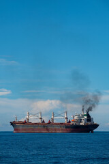 Rusty Red Cargo Ship on the Blue Ocean