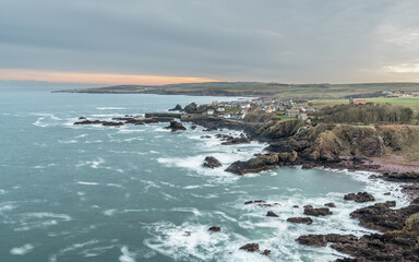 Fototapeta na wymiar Long exposure of the sea, rocky coastline, Town and Harbour, St Abbs, Scotland