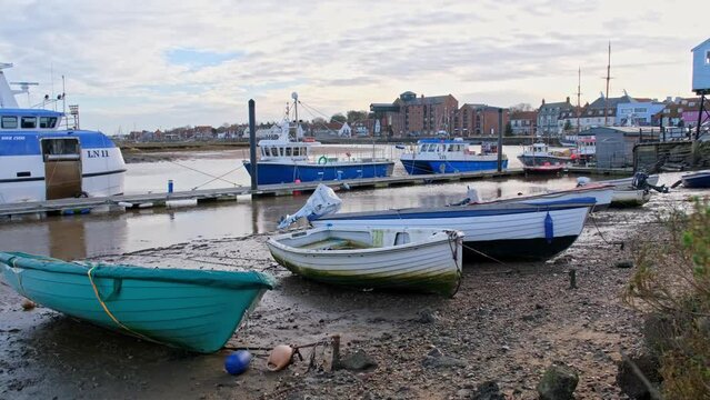 View across the boats moored in the harbour at low tide and towards the town