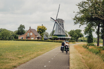 Familie passiert während einer Fahrradtour durch die Niederlande eine typische holländische...