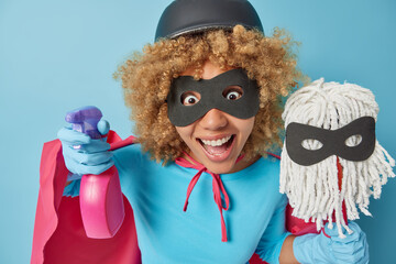 Horizontal shot of surprised curly haired female housewife hold bottle of cleaning detergent and...