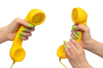 Yellow handset in woman hand with green nails isolated on a white background.