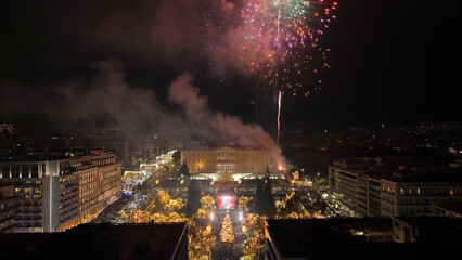 Aerial drone night shot of illuminated iconic Syntagma square at new year's eve celebration with fireworks welcoming 2024, Athens, Attica, Greece