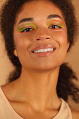 Beauty portrait of attractive young african american woman with neon color make-up smiling at camera