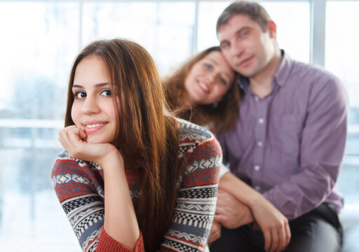 Smiling teenage girl sitting in front of her parents