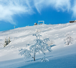 Morning winter calm mountain landscape with beautiful frosting trees, snowdrifts on slope and ski...